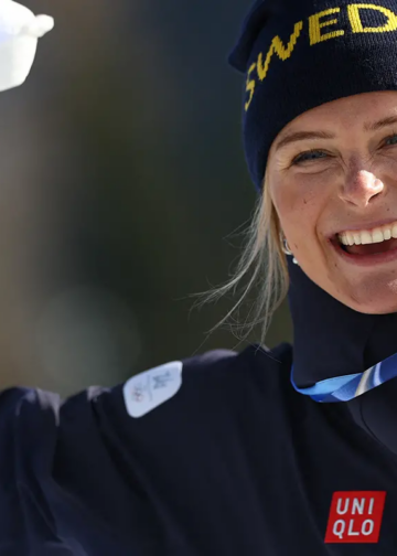 Frida Karlsson håller upp sin guldmedalj efter segern på 10 kilometer fristil vid OS 2026.