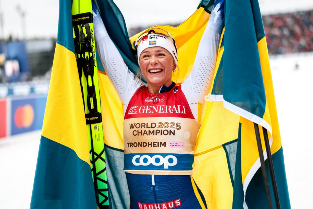 Frida Karlsson firar VM-guldet på 50 kilometer med en svensk flagga i Trondheim 2025.