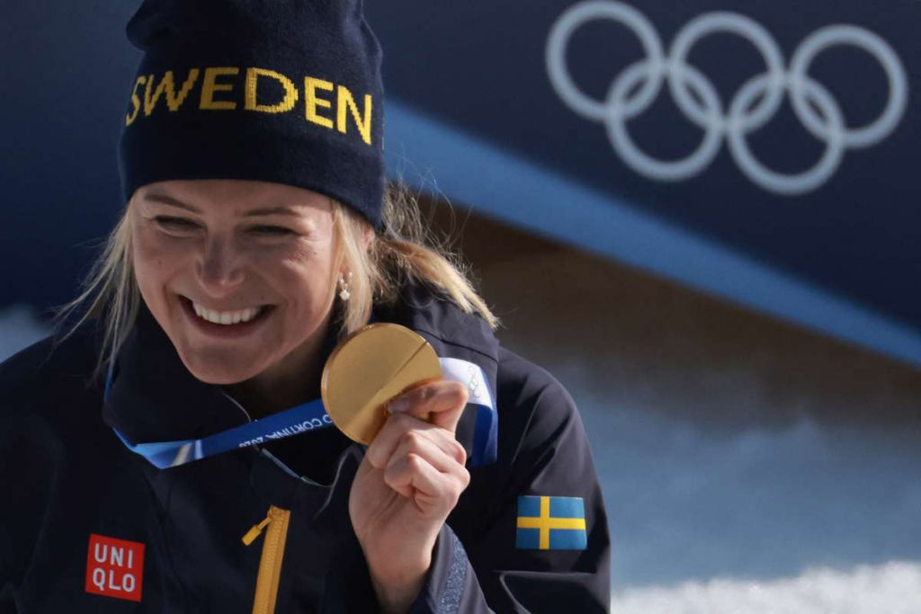 Frida Karlsson ler med OS-guldmedaljen efter 10 kilometer fristil 2026.